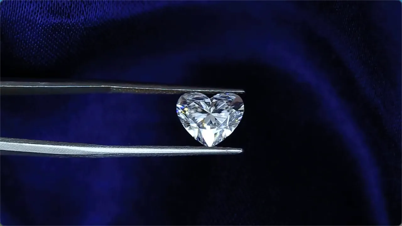 Heart-shaped loose stone held in tweezers